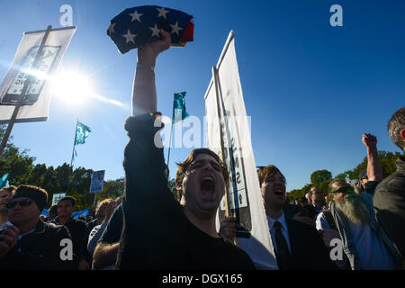 Washington DC, USA. 26th Oct, 2013. DUSTIN VAUGHN, from Dallas Texas, holds a flag at a protest against the National Security Administration's domestic and international spying programs at the National Mall. Thousands took part in the rally to demand greater oversight of the agency on the 12th anniversary of the passage of the Patriot Act, which authorized the use of wiretapping and other surveillance programs. Credit:  ZUMA Press, Inc./Alamy Live News Stock Photo