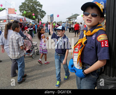 Olive Branch, MS, USA. 26th Oct, 2013. October 26, 2013 - Cub Scouts Pack 123 members Jake Phillips, 8, and Drake Sanders, 9, sell popcorn during Fall Fest on the Roost in Old Towne, Olive Branch on Saturday. As Sanders stayed cool on a light post, Phillips could be heard chanting, ''Popcorn for sale. The best popcorn in the universe. Popcorn for sale. It's great for weight lifting. © Yalonda M. James/The Commercial Appeal/ZUMAPRESS.com/Alamy Live News Stock Photo