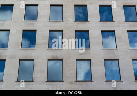 Symmetrical windows surrounded by clean stone cladding Stock Photo