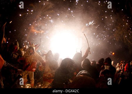 People dance surrounded by fire and pyrotechnics during a traditional fire run in the island of Mallorca, Spain Stock Photo