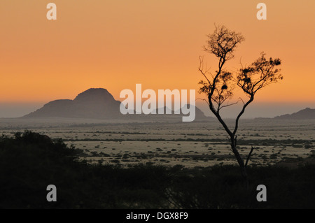 Fog from the Atlantic Ocean rolling in over the Namib desert and the Klein Spitzkuppe at sunset. Stock Photo