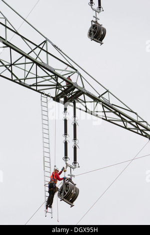 Lineman working with a wire rope hoist on a 380-kV long-distance line owned by the 50Hertz transmission system operator, track Stock Photo