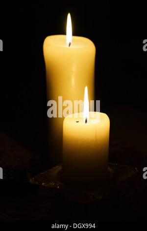 Two candles burning in the dark Stock Photo