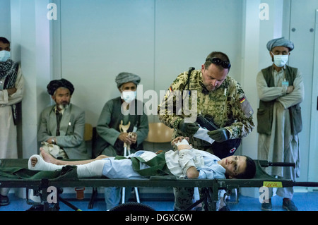 Bundeswehr doctor treating an Afghan boy in PRT Feyzabad, a field hospital of the Federal Defence Forces of Germany, Feyzabad Stock Photo