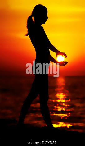 Silhouette of woman holding sun in hand background Stock Photo - Alamy