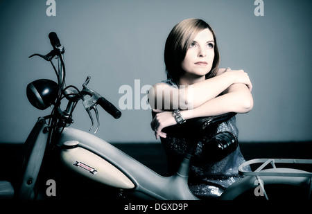 Young woman with a vintage Motom motorcycle Stock Photo