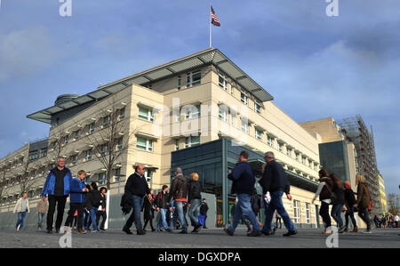 Berlin, Germany. 27th Oct, 2013. The American flag waves ontop of the US embassy as people walk past in Berlin, Germany, 27 October 2013. Photo: PAUL ZINKEN/dpa/Alamy Live News Stock Photo