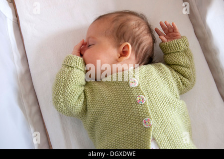 Little baby girl asleep in her crib and sucking her thumb Stock Photo