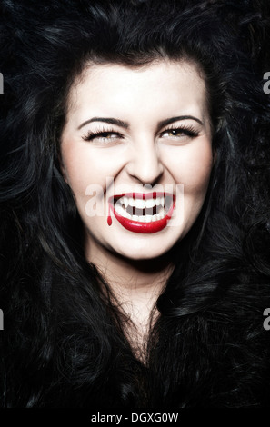 Young Woman dressed as a vampire with blood on her red lips, Austria Stock Photo