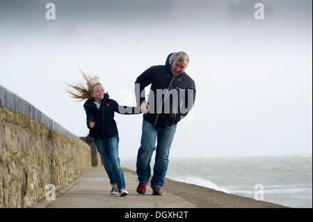 Porthcawl, Wales, UK. October 27. Strong winds at Porthcawl, South Wales as a major atlantic storm moves across the UK. The stormy weather will continue into Monday with winds gusting at up to 80mph.  Pictured are Matthew and Mia Jones of Porthcawl.  Matthew Horwood / Alamy Live News Stock Photo