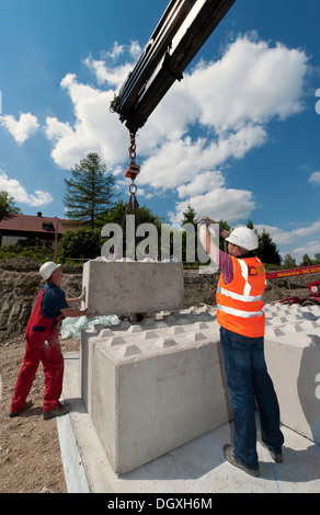 Structural engineers placing the first blocks during a building site load test, at a construction site in Fridolfing, Bavaria Stock Photo
