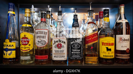Bottles of various spirits standing on the shelf in a bar Stock Photo