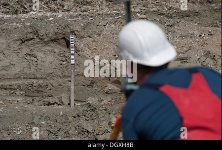 A structural engineer is taking measurements of a possible soil dropping during a building site load test, at a construction Stock Photo