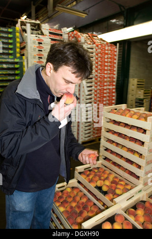 Francois Pasteau, chef from the L'Epi Dupin restaurant, controlling a peach in the fruit and vegetables hall, Pavillon des Stock Photo