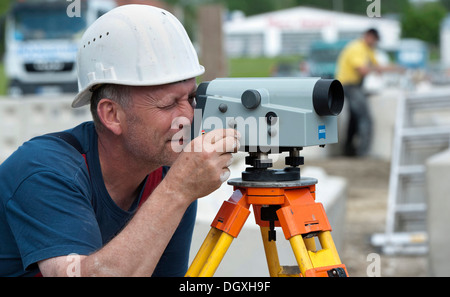 A structural engineer is taking measurements of a possible soil dropping during a building site load test, at a construction Stock Photo