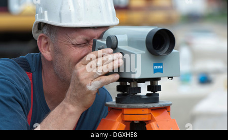 A structural engineer is taking measurements of a possible soil dropping during a building site load test, at a construction Stock Photo