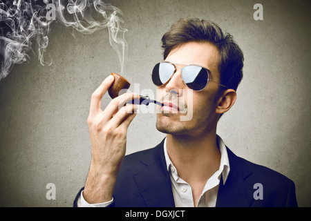 Young and elegant man smoking a pipe Stock Photo