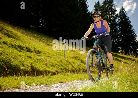 Female mountain biker riding a bike in the Alps near Lauenen, Canton Bern, Switzerland, Europe Stock Photo