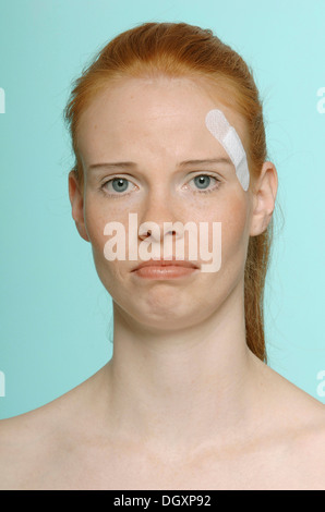 Young red-haired woman with a plaster, portrait Stock Photo