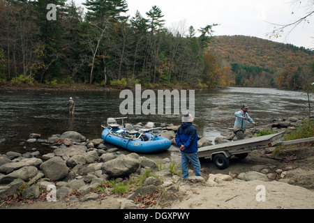 Fishermen haul their rubber raft ashore after a day of fishing on the Housatonic river in Litchfield county, Connecticut. Stock Photo