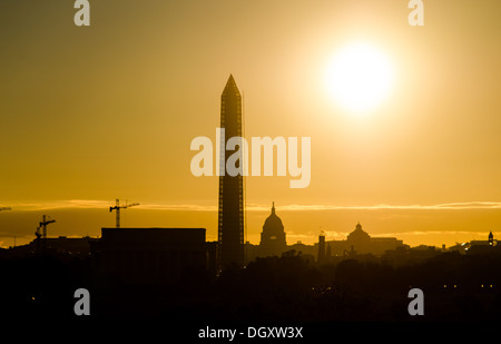 WASHINGTON DC, USA - The rising sun silhouettes the Lincoln Memorial, Washington Monument, and US Capitol Dome on Washington DC's National Mall. Stock Photo