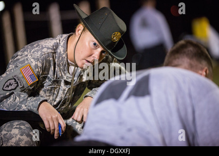 A female Drill Sergeant instructor monitors a Drill Sergeant candidate at the US Army Drill Instructors School Fort Jackson during the entry physical training test early morning September 27, 2013 in Columbia, SC. While 14 percent of the Army is women soldiers there is a shortage of female Drill Sergeants. Stock Photo