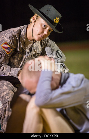 A female Drill Sergeant instructor monitors a Drill Sergeant candidate at the US Army Drill Instructors School Fort Jackson during the entry physical training test early morning September 27, 2013 in Columbia, SC. While 14 percent of the Army is women soldiers there is a shortage of female Drill Sergeants. Stock Photo