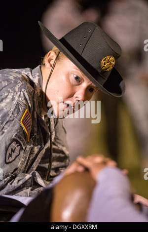 A female Drill Sergeant instructor monitors a Drill Sergeant candidate at the US Army Drill Instructors School Fort Jackson during the entry physical training test early morning September 27, 2013 in Columbia, SC. While 14 percent of the Army is women soldiers there is a shortage of female Drill Sergeants. Stock Photo