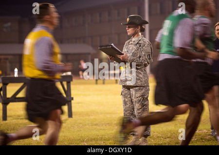 A female Drill Sergeant instructor monitors Drill Sergeant candidates at the US Army Drill Instructors School Fort Jackson during the entry physical training test early morning September 27, 2013 in Columbia, SC. While 14 percent of the Army is women soldiers there is a shortage of female Drill Sergeants. Stock Photo