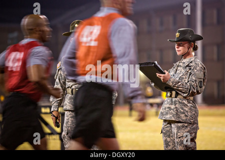 A female Drill Sergeant instructor monitors Drill Sergeant candidates at the US Army Drill Instructors School Fort Jackson during the entry physical training test early morning September 27, 2013 in Columbia, SC. While 14 percent of the Army is women soldiers there is a shortage of female Drill Sergeants. Stock Photo