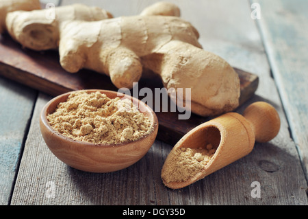 Fresh ginger root and ground ginger spice on wooden background Stock Photo