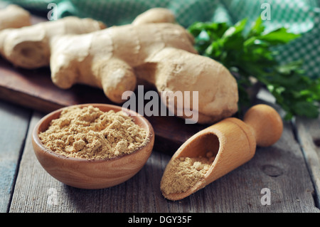 Fresh ginger root and ground ginger spice on wooden background Stock Photo