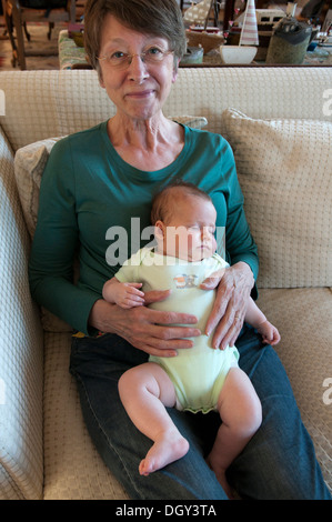 Grandmother smiling cuddling her little granddaughter Stock Photo