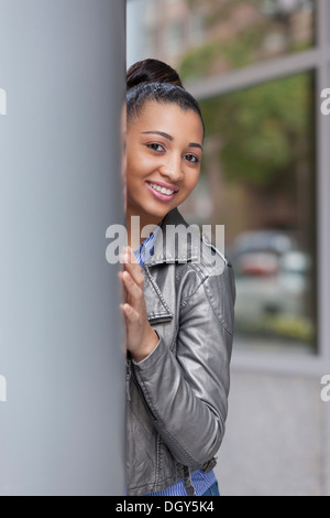 Young African-American woman with hair up in urban environment Stock Photo