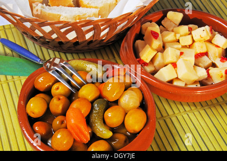Spanish tapas of Green olive salad, bread and Manchego cheese with chilli in oil, Andalusia, Spain, Western Europe. Stock Photo