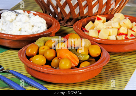Selection of tapas - From left to right: Potato salad, Green Olive Cocktail, Cubed Manchego cheese in olive oil with chilli. Stock Photo