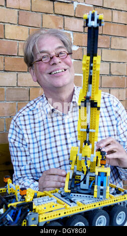 Active, senior technology enthusiast enjoying his hobby and demonstrating his self-built crane Stock Photo