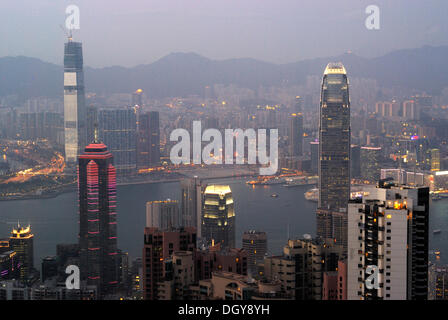 View from Victoria Peak on the nightly illuminated Hong Kong with skyscrapers and high-rise buildings of Central and Kowloon Stock Photo
