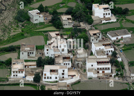 View on the Tibetan architecture of a small village, Tibetan houses in a steep canyon with field terraces for cultivation Stock Photo