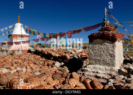 Prayer flags, mani stones and chorten of Chiu Gompa monastery in front of snow-covered Mount Kailash, Kang Rinpoche in Tibetan Stock Photo