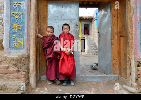 Two young novice monks, students, in front of a Buddhist monastery school, monastery building in the traditional architectural Stock Photo