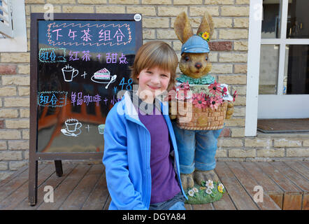 Girl, 6, in front of the Easter bunny in an old traditional hutong, a traditional residential courtyard, in Beijing, China, Asia Stock Photo