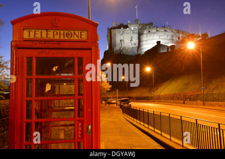 Edinburgh Castle, illuminated at night, old red British phone booth at front, Edinburgh, Scotland, United Kingdom Stock Photo