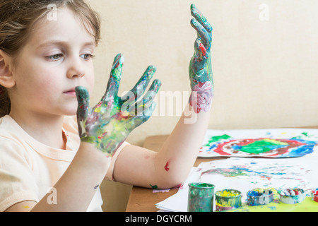 Girl looking at her painted hands Stock Photo