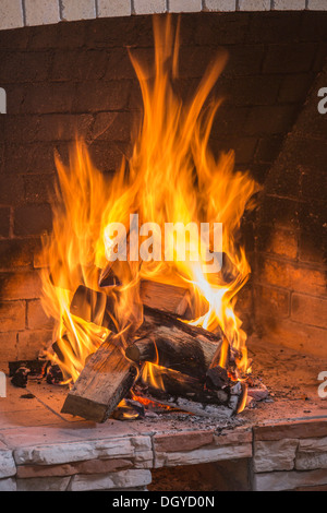 A stack on fire wood ablaze in an open fire Stock Photo