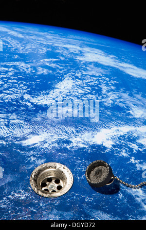 An unplugged drain in Earth with sink plug next to it, digital composite Stock Photo