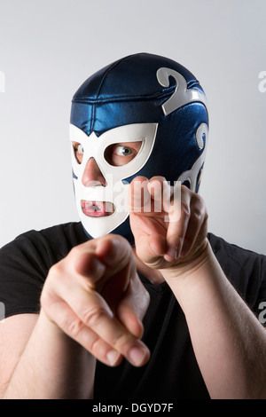 A man wearing a Lucha Libre wrestling mask and gesturing bizarrely with his hands Stock Photo