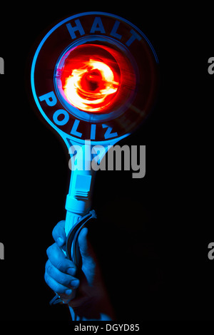 A hand holding a police warning sign with the German Halt Polizei on it Stock Photo
