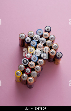 A large group of batteries arranged into the shape of an arrow, pointing up Stock Photo