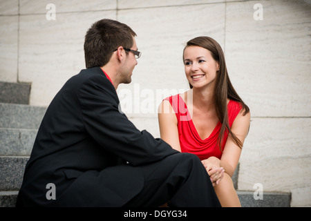 Colleagues - young business people having conversation sitting on stairs Stock Photo